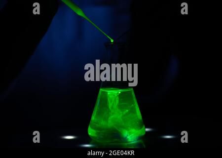 A close up view of a chemistry reasercher performing a photochemical reaction in conical flask for pharmaceutical research Stock Photo