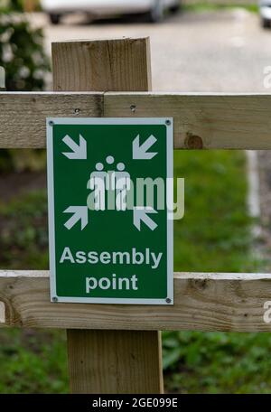A green and white 'Assembly Point' sign. This sign is used to show  the designated area where people should gather in the event of an emergency Stock Photo