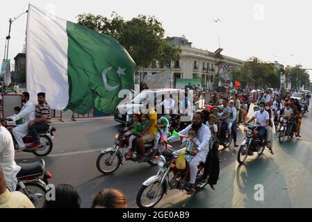 Lahore, Pakistan. 14th Aug, 2021. Pakistani people from different walk holding national flags as they celebrate 75th Independence Day in Lahore, Pakistan on August 14, 2021. The 75th Independence Day celebrations across the country are underway with traditional zeal and enthusiasm. The country gained its independence from the British rule on August 14, 1947. During the celebration, people parade and dress-up in green and white, which are Pakistan's official flag colors. (Photo by Rana Sajid Hussain/Pacific Press/Sipa USA) Credit: Sipa USA/Alamy Live News Stock Photo