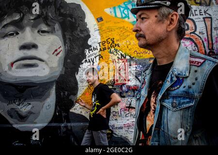 Moscow, Russia. 15th of August, 2021 Fans of Viktor Tsoi's rock singer and poet commemorate the memory of the singer near the Tsoi Wall on Arbat street in Moscow on the 31st anniversary of the singer's death, Russia. The Tsoi Wall is a graffiti-covered wall in Moscow, dedicated to musician Viktor Tsoi and his band Kino Stock Photo