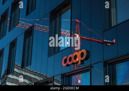 ALTSTETTEN-ZH, SWITZERLAND - FEBRUARY 20, 2020: On the wall of the building is the inscription of the Coop retail chain, as well as a reflection of th Stock Photo