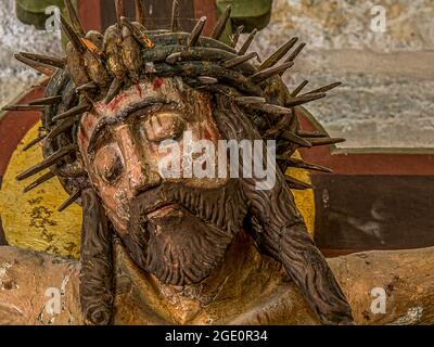 Jesus with the crown of thorns, an old colored crucifix from the 15th century with peeled painting, Borrie church, Sweden, July 16, 2021 Stock Photo