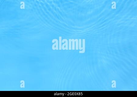The surface of light on the blue transparent swimming pool water. Trendy abstract wavy background. Water waves in sunlight banner Stock Photo