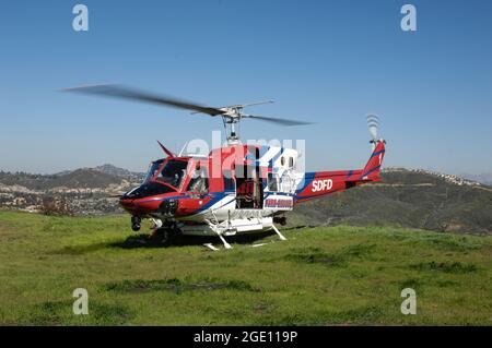 San Diego Fire-Rescue Copter 1 on hilltop prior to beginning airlift of civilians with hoist. Stock Photo
