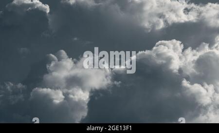Dramatic rainclouds lit with bright sun, clouds in gray sky Stock Photo