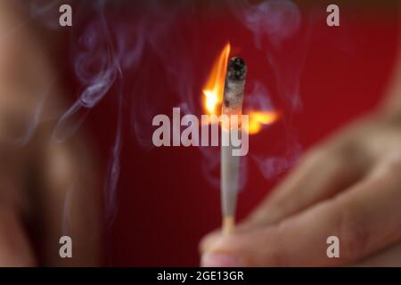 Woman hand holding burning hunting match closeup Stock Photo