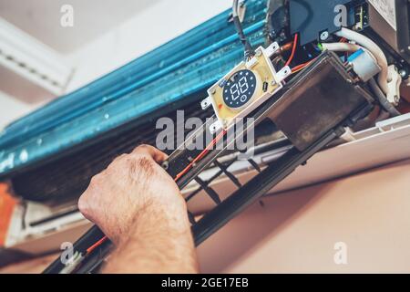 Technician repairing air conditioner inside close up. Stock Photo