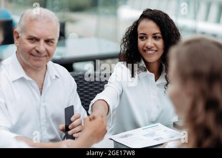 smiling businesswoman shaking the hand of her colleagues. Stock Photo