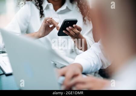 image of a businesswoman using her smartphone at an office meeting. Stock Photo