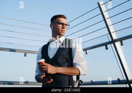 young businessman with a takeaway coffee standing on the office Stock Photo