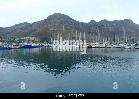 Hout Bay Marina with yachts and Chapman's Peak in the background at Hout Bay, a coastal town near Cape Town, South Africa. Stock Photo