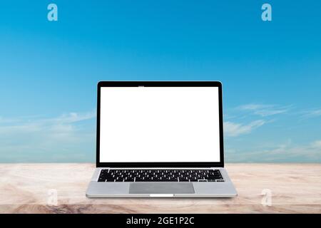 Laptop computer with blank screen on wood table over blur nature sky background. Mock up, template for your design. Stock Photo