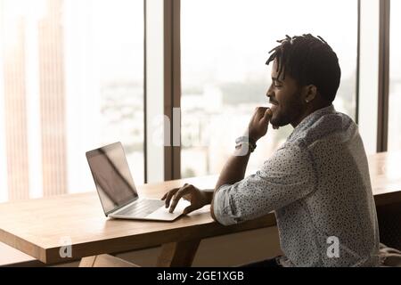 African man working on laptop sit in modern coworking space Stock Photo