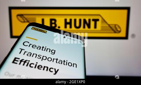 Smartphone with website of logistics company J.B. Hunt Transport Services Inc. on screen in front of logo. Focus on top-left of phone display. Stock Photo