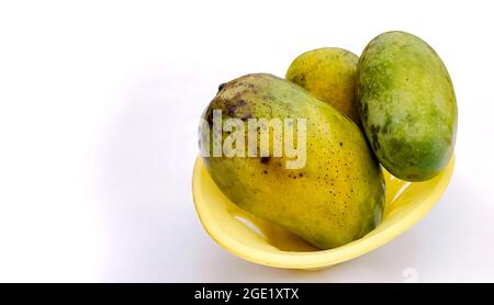 Three large ripe mangoes in a basket isolated on white background Stock Photo