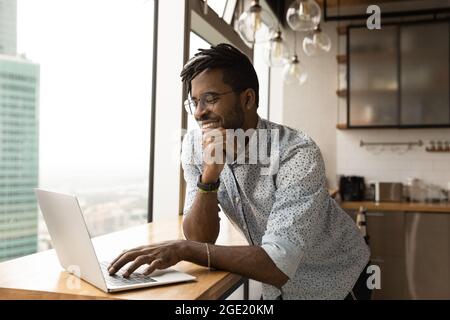African guy working on computer smiling lead pleasant remote chat Stock Photo