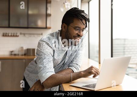 Handsome hipster guy using laptop watch webinar entertaining online content Stock Photo
