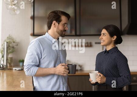 Multiracial colleagues talking during lunch break in office kitchen Stock Photo
