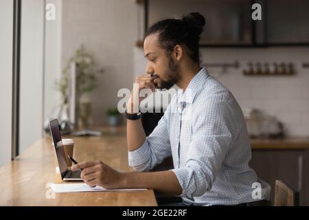 African businessman sit at table working on research using laptop Stock Photo
