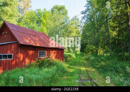 Old red shed at a narrow-gauge railroad in the woodland Stock Photo