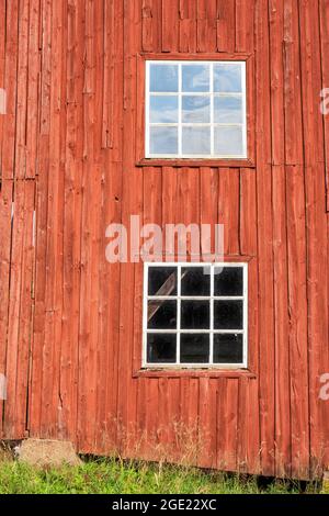 Red wall with white windows on a barn Stock Photo