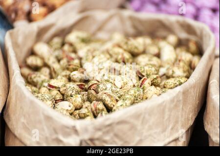 Assorted nuts in paper boxes for sale in the market. Selective focus. Stock Photo