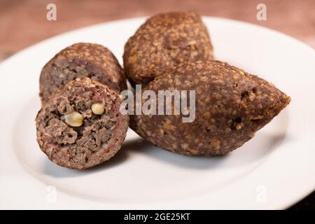 Traditional kebbe and pita bread on big round plate in lebanese restaurant Stock Photo