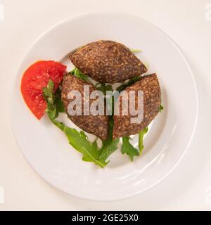 Traditional kebbe and pita bread on big round plate in lebanese restaurant Stock Photo