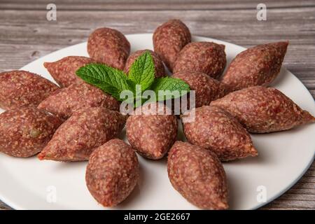 Traditional kebbe and pita bread on big round plate in lebanese restaurant Stock Photo