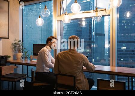 Two busy colleagues working late on common project in office Stock Photo