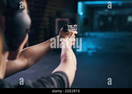 Shooter practicing a two-handed hold at a shooting range Stock Photo