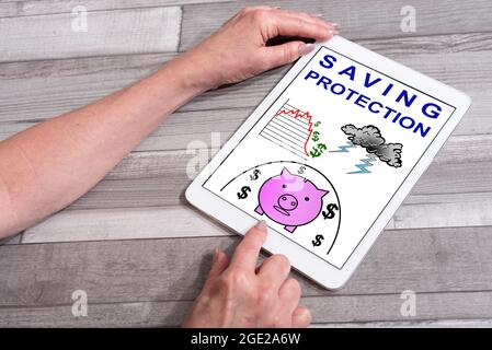 Saving protection concept shown on a tablet used by a woman Stock Photo