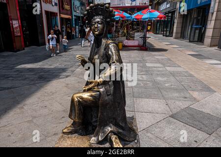 ZHENGZHOU, CHINA - Jul 08, 2021: A female metal statue depicting old times in the streets of Zhengzhou, China Stock Photo