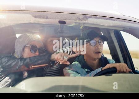 group of happy asian friends enjoying a sightseeing trip by car Stock Photo