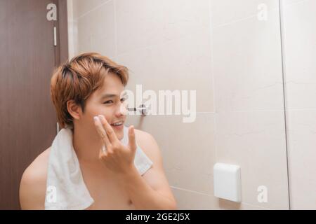 Handsome man washing face in bathroom Stock Photo