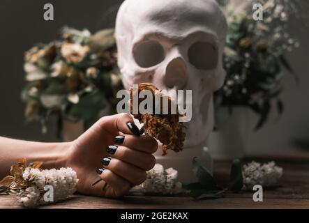 Close-up of a female hand holding a bouquet of wilted flowers. Stock Photo