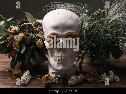 Romantic Gothic still life with withered flowers and a skull. Stock Photo