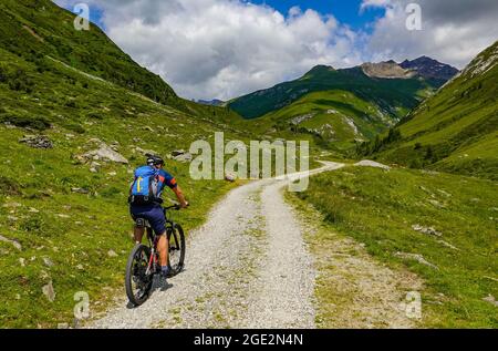 20 July 2021, Austria, Sankt Jakob: A mountain biker is riding an e-bike in Defereggental in Tyrol. The Defereggen valley lies in the middle of the Hohe Tauern National Park. The valley is surrounded by mountains of the Deferegg mountains, the Rieserferner group, the Lasörling group and the Schober group. Photo: Patrick Pleul/dpa-Zentralbild/ZB Stock Photo