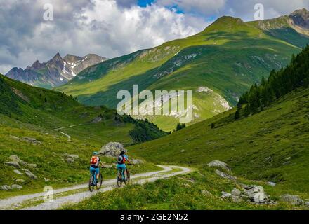 20 July 2021, Austria, Sankt Jakob: Mountain bikers with e-bikes are on the road in Defereggental in Tyrol. The Defereggen valley lies in the middle of the Hohe Tauern National Park. The valley is surrounded by mountains of the Deferegg mountains, the Rieserferner group, the Lasörling group and the Schober group. Photo: Patrick Pleul/dpa-Zentralbild/ZB Stock Photo