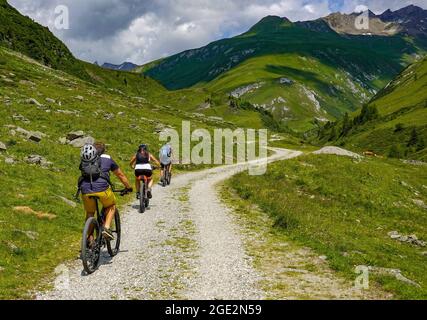 20 July 2021, Austria, Sankt Jakob: Mountain bikers with e-bikes are on the road in Defereggental in Tyrol. The Defereggen valley lies in the middle of the Hohe Tauern National Park. The valley is surrounded by mountains of the Deferegg mountains, the Rieserferner group, the Lasörling group and the Schober group. Photo: Patrick Pleul/dpa-Zentralbild/ZB Stock Photo