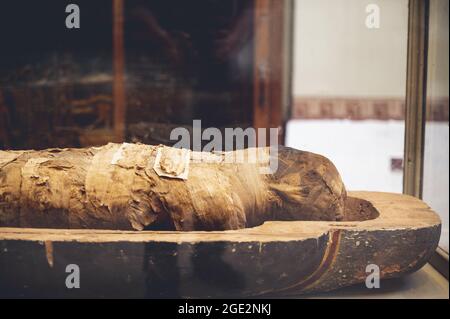CAIRO, EGYPT - Jun 06, 2021: A closeup of a mummy with an open lid in the Egyptian Museum in Cairo, revealing a wrapped person Stock Photo