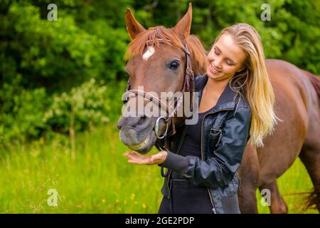 Smiling woman and her happy arabian horse friend in the nature Stock Photo