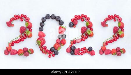 The figures 2022 are made of red currants, raspberries and strawberries and black blueberries.The event is Christmas and New Year, a symbol.Healthy an