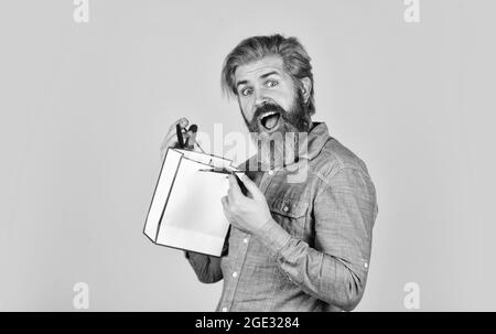 Bearded man hold shopping bags. Retail concept. Happy holidays. Handsome buyer. Seasonal sale. Boost sales. Hipster buying sale price. Black Friday Stock Photo