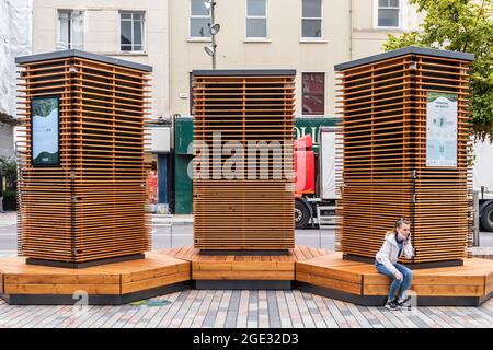 Cork, Ireland. 16th Aug, 2021. The controversial robot trees installed in Cork City centre made the perfect place to stop for a cigarette today. Credit: AG News/Alamy Live News Stock Photo