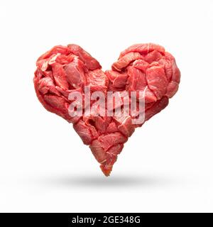 the heart is made from raw meat isolate. beef in the shape of a heart, symbolizes heart disease, overeating, cooking or the meat industry, as well as Stock Photo