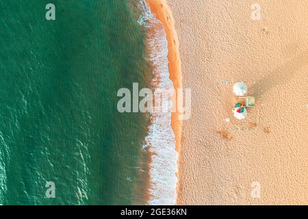 Aerial top view on the beach. Umbrellas, sand and sea waves Stock Photo
