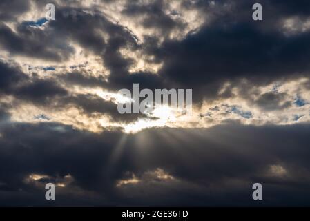 Rays of light shining throug dark clouds.Beautiful dramatic sky with sun rays.dramatic sky sun rays. Stock Photo