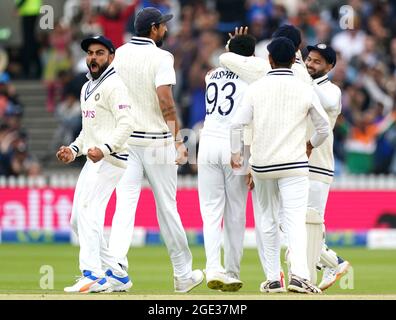 India's Virat Kohli (left) celebrates after Mohammed Siraj catches the ball of England's Rory Burns during day five of the cinch Second Test match at Lord's, London. Picture date: Monday August 16, 2021. Stock Photo