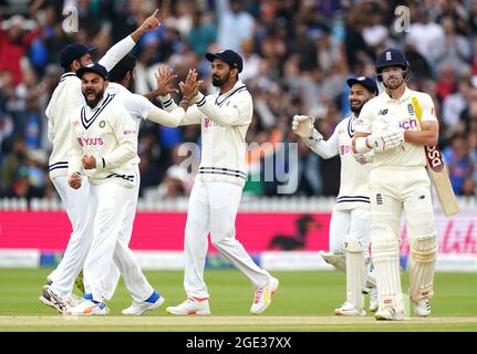 India's Virat Kohli (left) celebrates after Mohammed Siraj catches the ball of England's Rory Burns (right) during day five of the cinch Second Test match at Lord's, London. Picture date: Monday August 16, 2021. Stock Photo